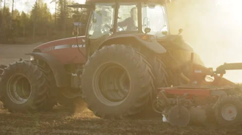 Tractor working in the grain fields in slow motion - lens flare and sunset 動画素材 40243188