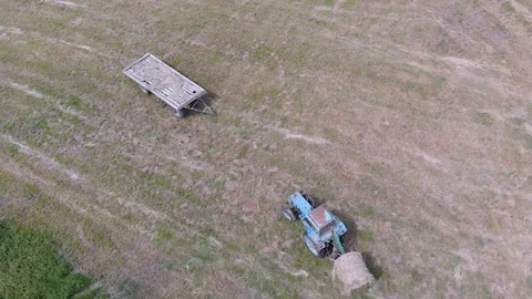 Tractor working on hay bales during summer in 4K Stock Footage 100702937