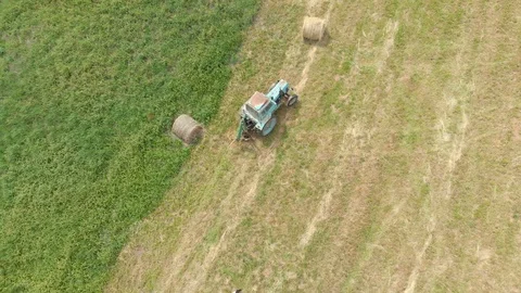 Tractor working on hay bales in a field in 4K Stock Footage 100702573