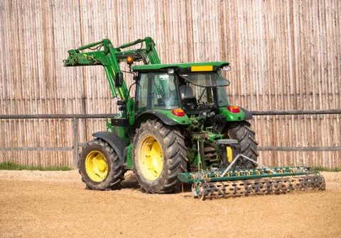 Tractor working on riding place Stock Photos