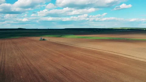 Tractor works on a big field, preparing soil for planting. Stock Footage 137388967