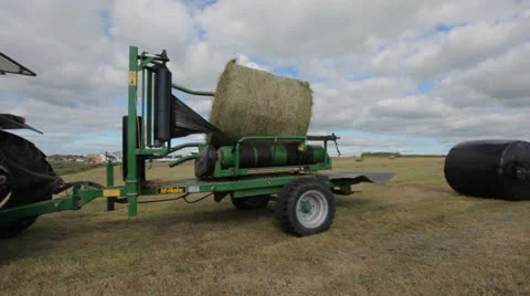 Tractor wrapping bail of hay 스톡 동영상 22899942