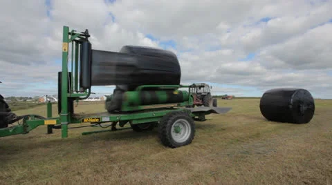 Tractor wrapping bail of hay Stock Footage 22900268