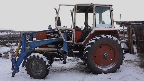 The tractor is in the yard. Winter. Countryside Stock Footage 102384386
