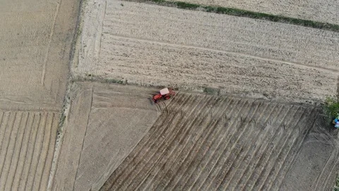 Tractors going in the opposite direction and cultivating land 動画素材 111991791