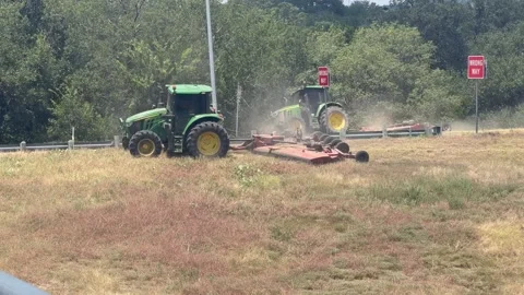 Tractors mowing grass next to highway in Austin, Tx 8/3/2026 Stock Footage 341362990