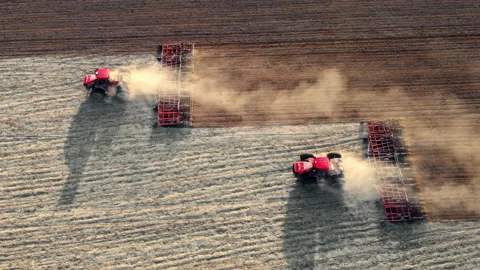 Tractos plowing ground preparing soil for palnting seeds. Agriculture farm Stock Footage 190597232