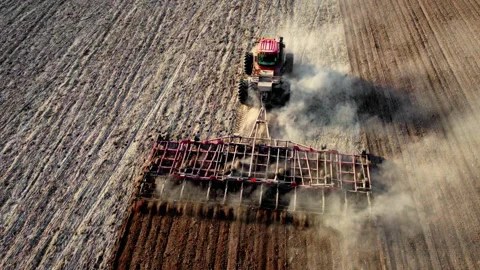 Tractos plowing ground preparing soil for palnting seeds. Agriculture farm Stock Footage 195695909