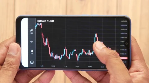 The trader Analysis The Bitcoin BTC Chart in the Smartphone App . Stock Footage 162481750