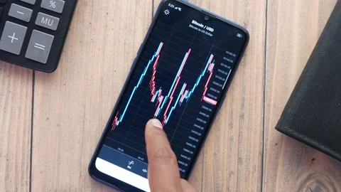 The trader Analysis The Bitcoin BTC Chart in the Smartphone App . Stock Footage 162481823