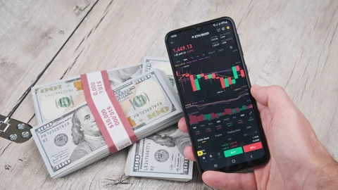 Trader Analyzes Ethereum Cryptocurrency Prices on Smartphone Above Dollars Stock Footage 211180413