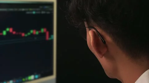 A trader is analyzing the candle bars on the screen, preparing a position t.. Stock Footage 308883092