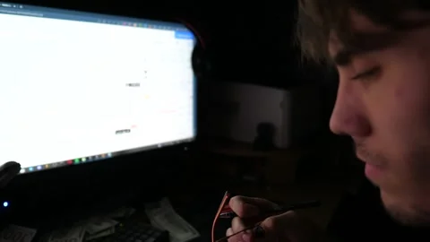 Trader analyzing stock graphs on multiple computer screens and making notes Stock-Footage 306582684