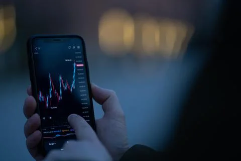 Trader checking stock market data on smartphone Stock Photos