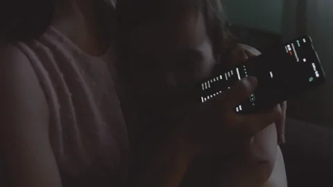 Trader investor analyst using mobile phone app while holding her child, toddler Stock Footage 250360680