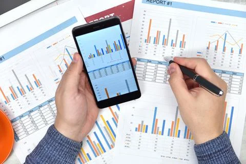 Trader man hands using smart phone with financial document. Foto stock