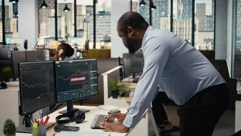 Trader in office alerted by hacking alert on trading platform dashboard Stock Photos