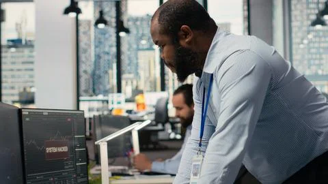 Trader in office alerted by hacking alert on trading platform dashboard Stock Photos