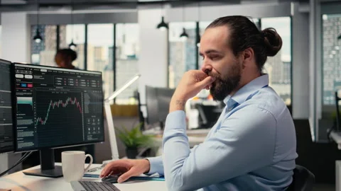 Trader in office doing brainstorming before committing to investment Video stock 315142410