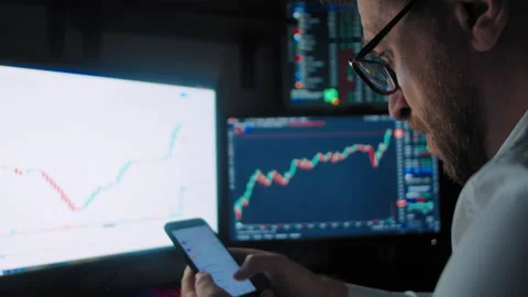 Trader scrolls the news on smartphone Stockbeeldmateriaal 170687540