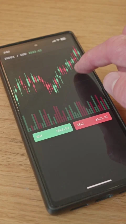 Trader tapping sell button on smartphone trading app to execute a successful Stock Footage 341860489