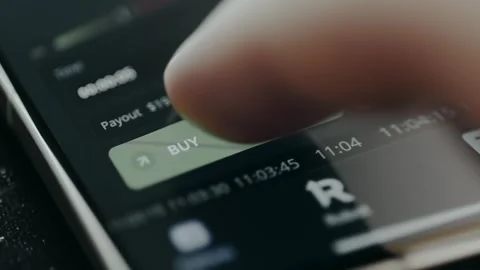 Trader taps the BUY button from a trading app Stock Footage 330252577