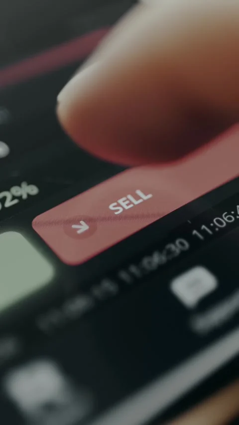 Trader taps the SELL button within a digital trading application interface Stock Footage 330252788