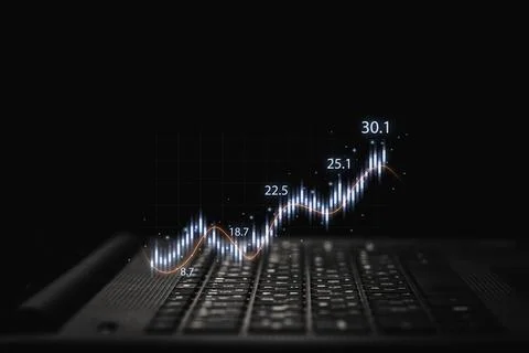 Trader using laptop computer with technical graph and chart Stock Photos