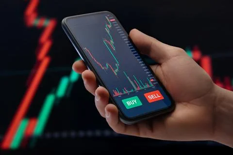 Trader using a mobile trading platform application on smartphone Stock Photos