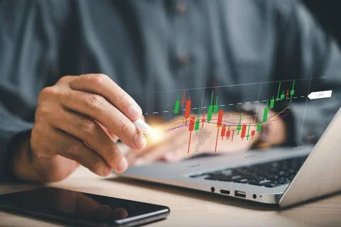 Trader utilizing technology to analyze candlestick chart, making informed s.. Stock Photos