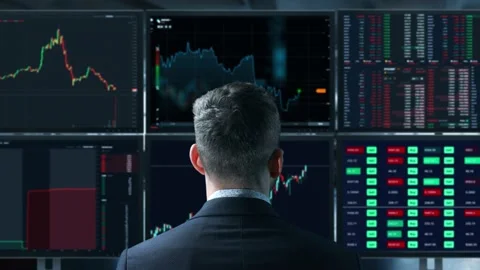 Trader is working with multiple computer screens full of charts and data Stock Footage 152896837