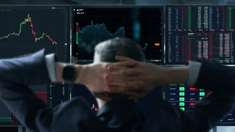 Trader is working with multiple computer screens full of charts and data 스톡 동영상 152934194