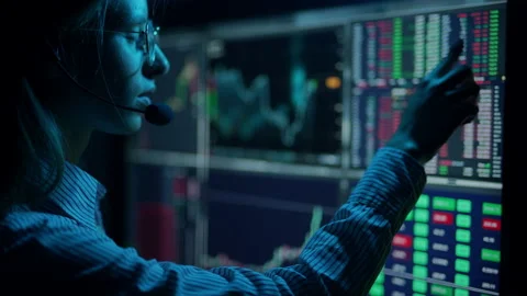 Trader is working with multiple computer screens with charts and data analysis Stock Footage 156703166