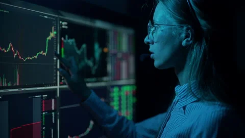 Trader is working with multiple computer screens with charts and data analysis Stock Footage 156703896