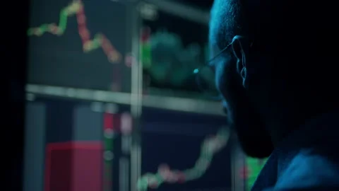 Trader is working with multiple computer screens with charts and data analysis Stock Footage 157562932