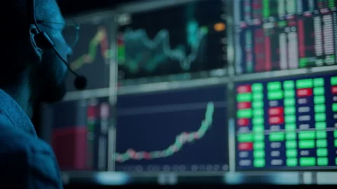 Trader is working with multiple computer screens with charts and data analysis Stock Footage 159628685
