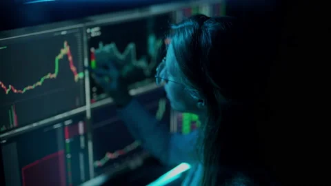 Trader is working with multiple computer screens with charts and data analysis Stock Footage 161110580