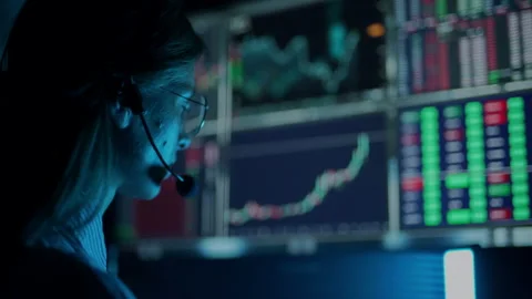 Trader is working with multiple computer screens with charts and data analysis Stock Footage 168534328
