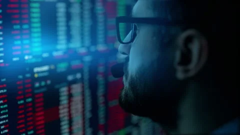 Trader is working with multiple computer screens with charts and data analysis Stock Footage 168971078