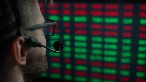 Trader is working with multiple computer screens with charts and data analysis Stock Footage 188443195