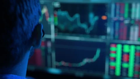 Trader is working with multiple computer screens with charts and data analysis 스톡 동영상 222638128