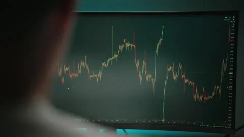 Trader working in office at night analyzing cryptocurrency data analyzing Stock Footage 317165736