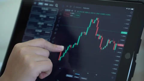 Trader is working with tablet. Screen with stock charts and data analysis. Stock Footage 240507949
