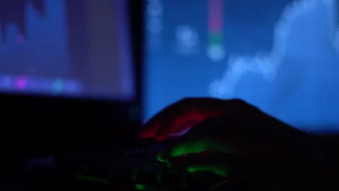 A trader works with a computer. Screen with stock charts and data analysis. Stock Footage 262973106