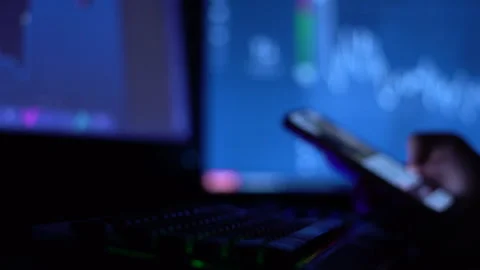 A trader works with a computer. Screen with stock charts and data analysis. Stock Footage 262973402