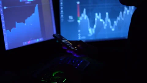 A trader works with a computer. Screen with stock charts and data analysis. Stock Footage 262975400