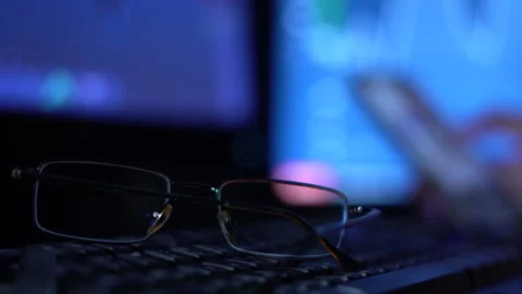 A trader works with a computer. Screen with stock charts and data analysis. Stock Footage 262976863