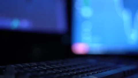 A trader works with a computer. Screen with stock charts and data analysis. Stock Footage 262977210
