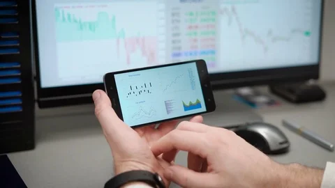The trader works with electronic reports on the rates of crypto currencies. The Stock Footage 82359232