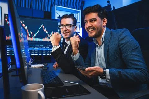 Traders comparing dynamic investment graph via phone and pc. Sellable. Stock Photos